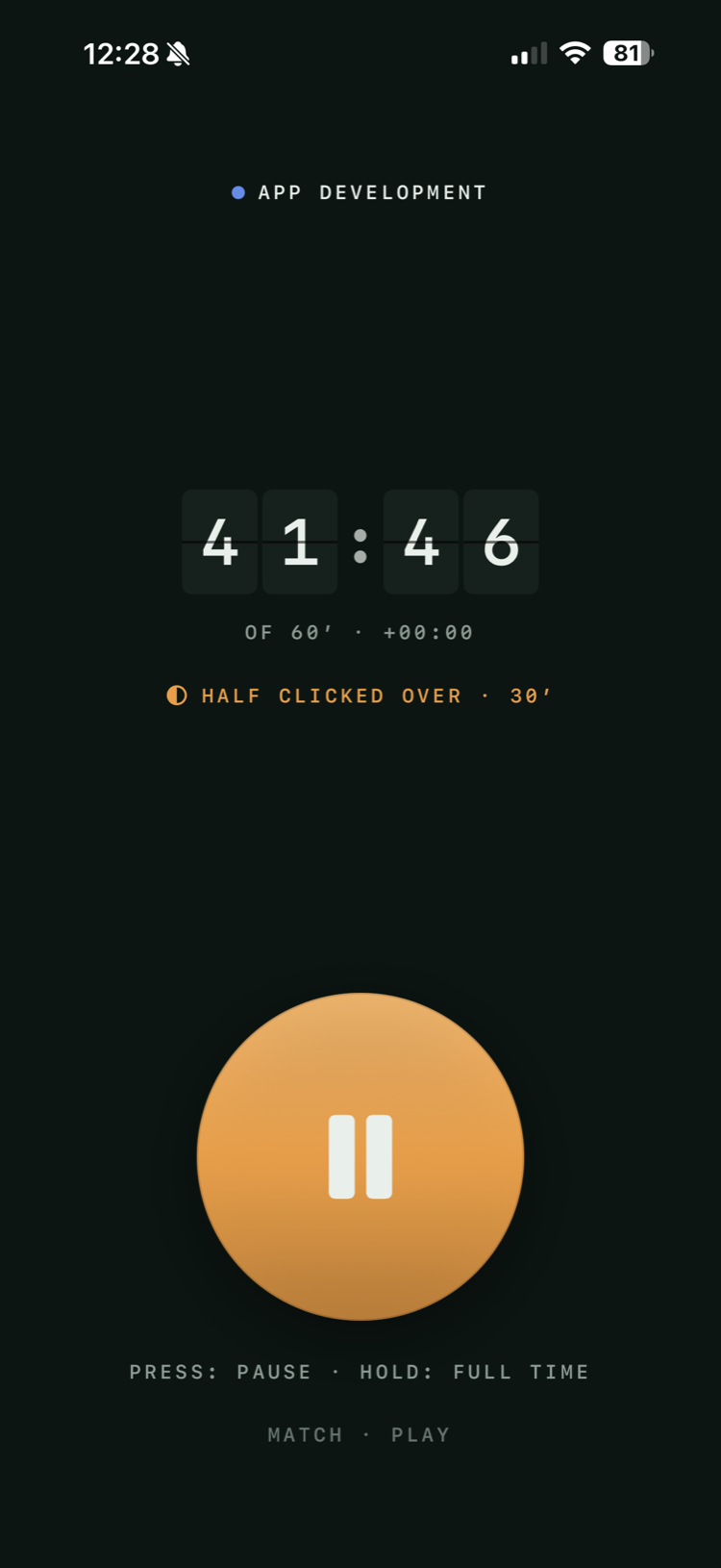The Match screen in play: a dark screen, the subject App development at the top, a split-flap clock reading 41:46, the line “of 60′ · +00:00” beneath it, a note that the half clicked over at 30′, and a large orange disc showing a pause symbol.